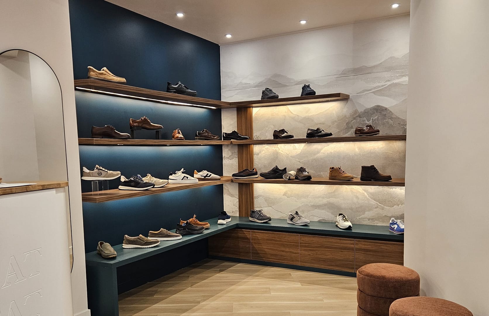 Espace homme de la boutique Kat’Pat à Voiron avec mobilier sur mesure en noyer, étagères LED et papier peint panoramique